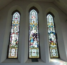 Three stained glass windows in Pagham Church